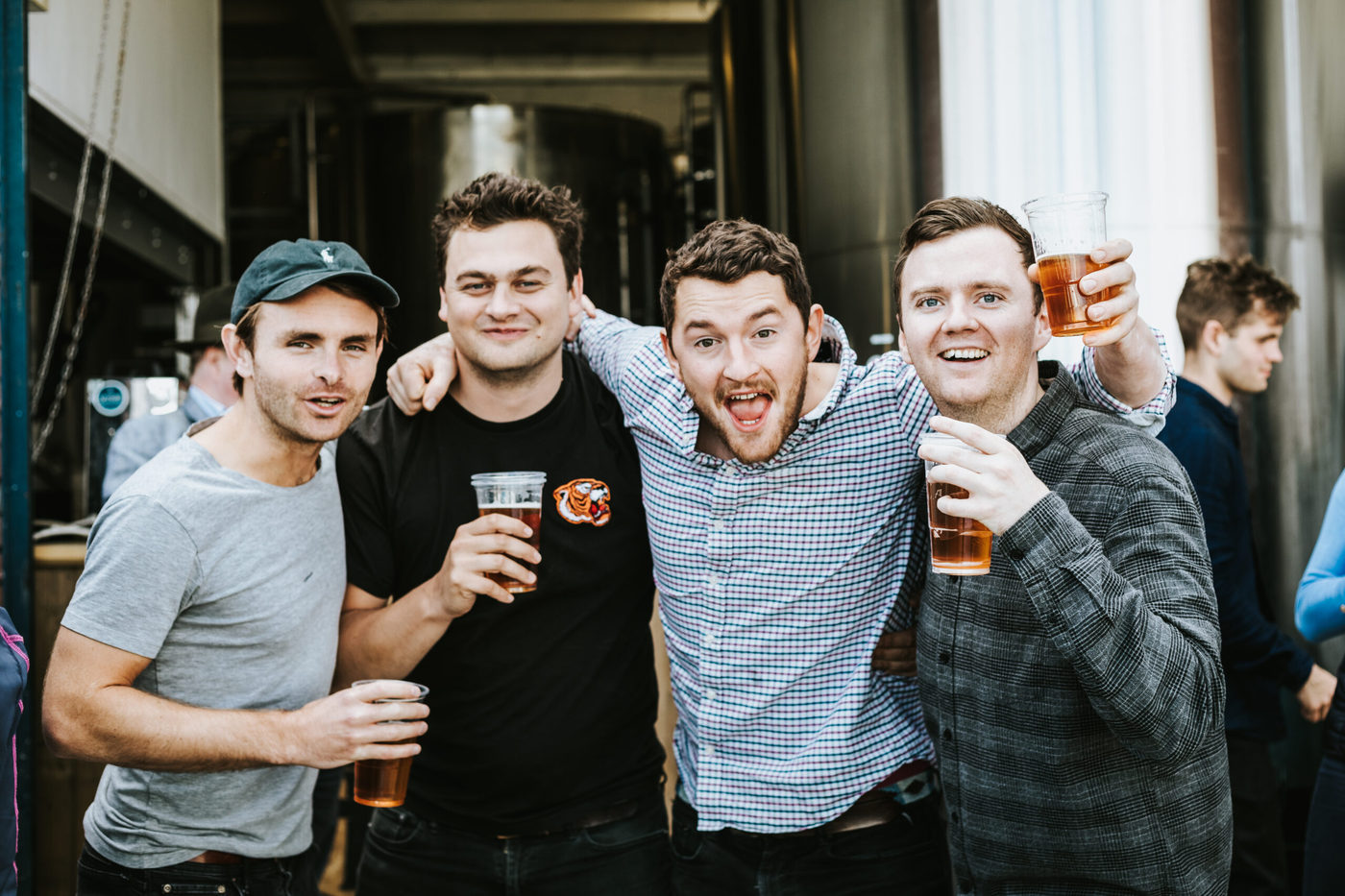 Group of friends drinking Sambrooks Brewery beers and smiling