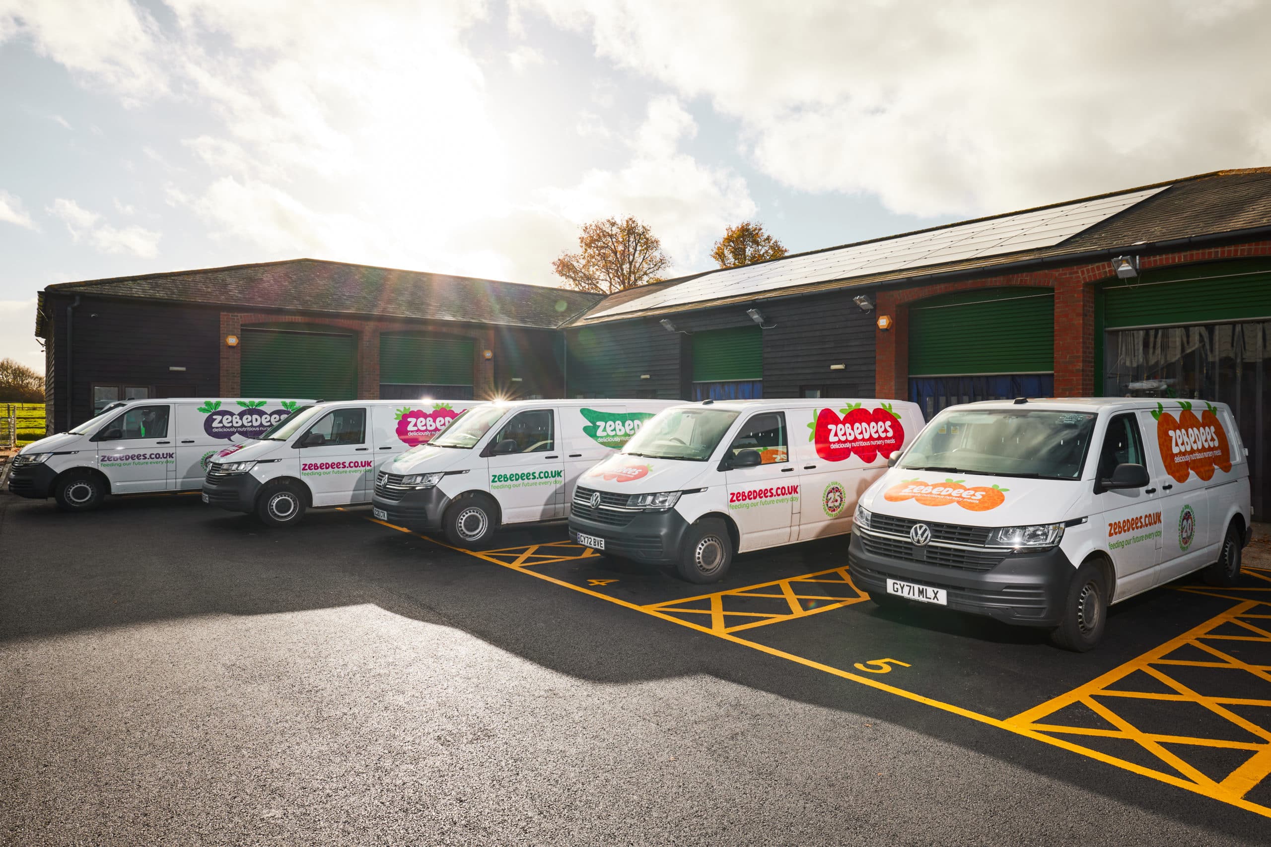Zebedees vans lined up with colourful logos
